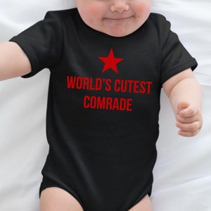 May include: Black baby onesie with a red star and the text "WORLD'S CUTEST COMRADE" in red.