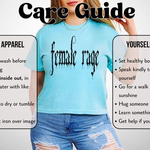 May include: A light blue t-shirt with the text "female rage" in a gothic font. The shirt is part of a care guide, with instructions for washing the apparel and tips for self-care, including setting boundaries and learning new things.
