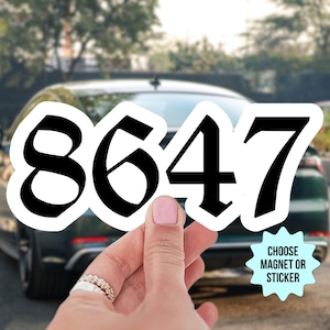 May include: A white sticker with black numbers 8647 in a bold font. The sticker is being held by a hand in front of a black car. The sticker says "Choose Magnet or Sticker" at the bottom.