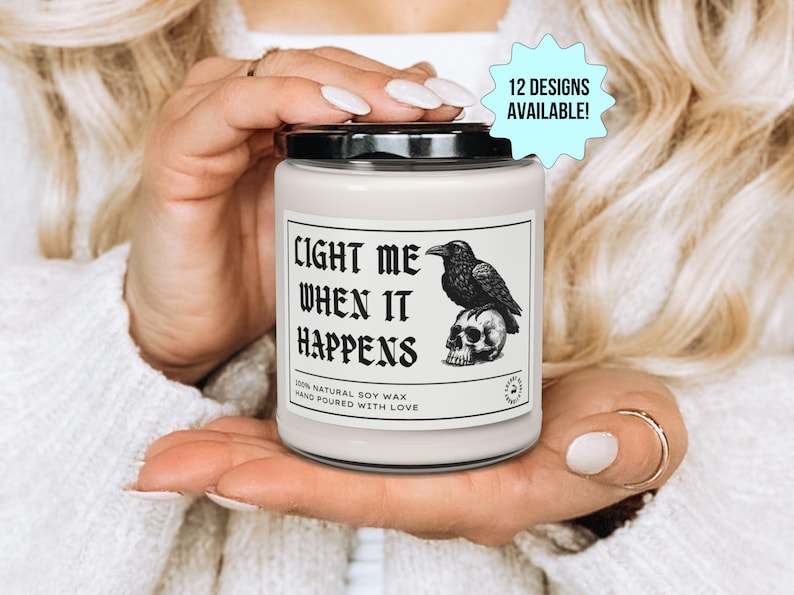 K&ouml;nnte beinhalten: Eine wei&szlig;e Kerze mit schwarzem Deckel, mit einem Etikett mit dem Text "LIGHT ME WHEN IT HAPPENS". Das Etikett zeigt auch einen Raben auf einem Totenkopf. 12 Designs sind verf&uuml;gbar.
