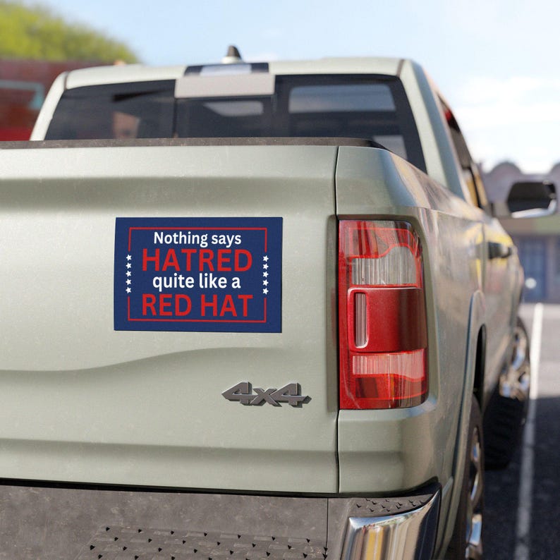 May include: A gray pickup truck with a bumper sticker that reads "Nothing says HATRED quite like a RED HAT".