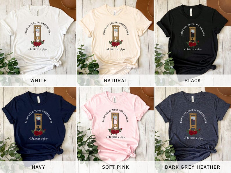 Puede incluir: Un conjunto de diez camisetas de diferentes colores, cada una con un gr&aacute;fico de una guillotina con el texto "Faire les coupes n&eacute;cessaires - Depuis 1789". Los colores incluyen blanco, natural, negro, azul marino, rosa suave y gris oscuro jaspeado.