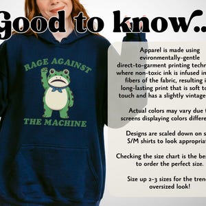 May include: Navy blue hoodie with a frog graphic and the text "RAGE AGAINST THE MACHINE". The frog is green and white, with a blue bow tie. The hoodie has a front pocket and a hood.