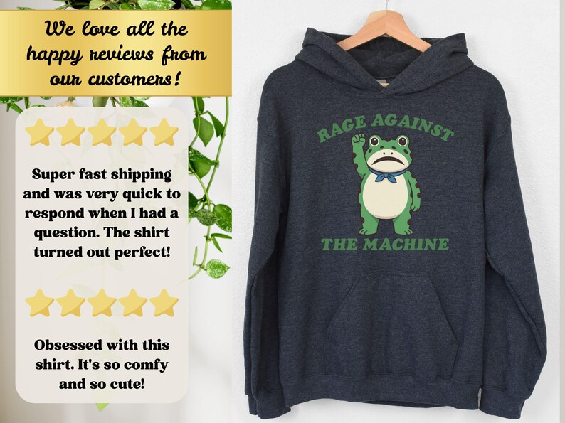 May include: Dark navy blue hoodie with a green frog graphic. The frog is raising a fist and wearing a blue bow tie. The text "RAGE AGAINST THE MACHINE" is above and below the frog in green.