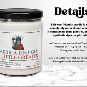 K&ouml;nnte beinhalten: Wei&szlig;e Kerze in einem Glas mit schwarzem Deckel. Das Etikett zeigt eine Illustration der Freiheitsstatue mit einem Weinglas und dem Text "AMERICA JUST GOT A LITTLE GREATER". Die Kerze misst 7,1 cm x 8,9 cm.