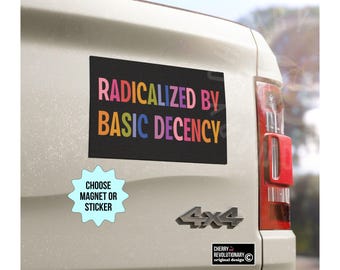 May include: A black rectangular magnet with the text "RADICALIZED BY BASIC DECENCY" in colorful letters is affixed to a vehicle. A light blue starburst sticker below reads "CHOOSE MAGNET OR STICKER".