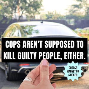 May include: Black rectangular magnet or sticker with white text: "COPS AREN'T SUPPOSED TO KILL GUILTY PEOPLE, EITHER." The background shows a car and a hand holding the magnet.