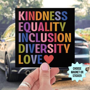 May include: A black square magnet or sticker with the words "KINDNESS EQUALITY INCLUSION DIVERSITY LOVE" in rainbow colors. A red heart is below the word "LOVE". The text "CHOOSE MAGNET OR STICKER" is on a blue starburst.