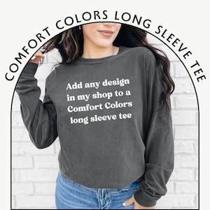 May include: A dark gray long-sleeved t-shirt with the text "Add any design in my shop to a Comfort Colors long sleeve tee" printed in white.