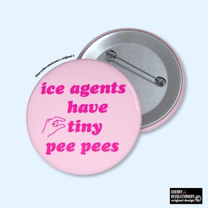 May include: A pink button with the text "ice agents have tiny pee pees" in pink. A hand graphic is also included. The button is round with a metal pin back. The button is a novelty item.