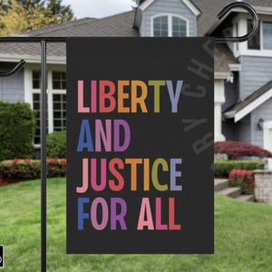 May include: A black garden flag with the words "LIBERTY AND JUSTICE FOR ALL" in colorful block letters. The flag is hanging on a black metal pole in front of a house with a green lawn.