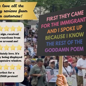 May include: A protest sign with the text "FIRST THEY CAME FOR THE IMMIGRANTS AND I SPOKE UP BECAUSE I KNOW THE REST OF THE GODDAMN POEM" in colorful letters. The sign is held up in a crowd of people.