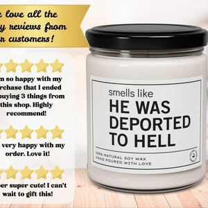 K&ouml;nnte beinhalten: Ein wei&szlig;es Kerzenglas mit schwarzem Deckel zeigt den Text "smells like HE WAS DEPORTED TO HELL". Das Etikett besagt auch "100% NATURAL SOY WAX HAND POURED WITH LOVE". Das Glas steht auf einer Holzoberfl&auml;che.