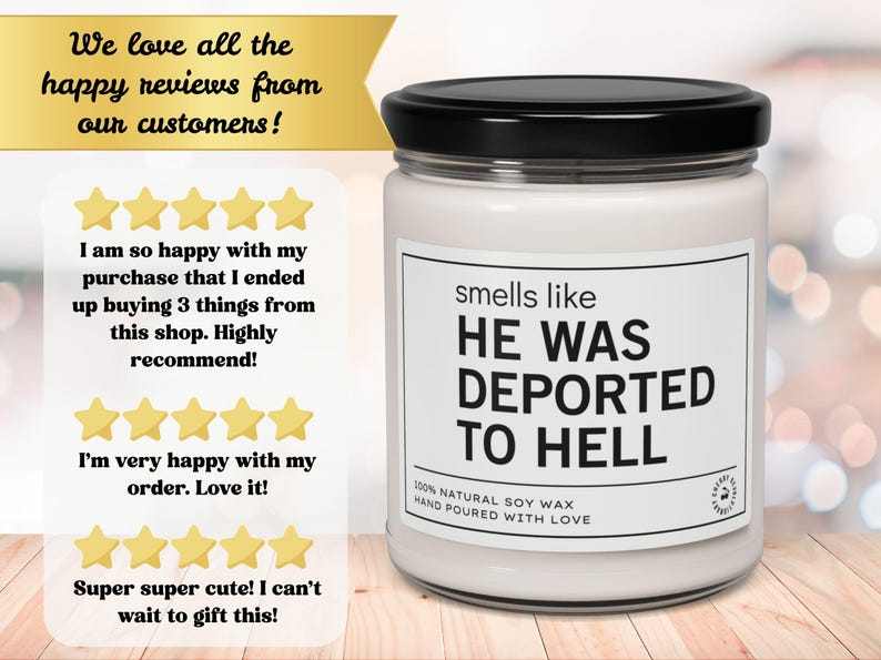 K&ouml;nnte beinhalten: Ein wei&szlig;es Kerzenglas mit schwarzem Deckel zeigt den Text "smells like HE WAS DEPORTED TO HELL". Das Etikett besagt auch "100% NATURAL SOY WAX HAND POURED WITH LOVE". Das Glas steht auf einer Holzoberfl&auml;che.