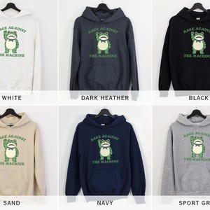 May include: A collection of hooded sweatshirts in various colors, including white, dark heather, black, sand, navy, and sport grey. Each sweatshirt features a green frog graphic with the text "RAGE AGAINST THE MACHINE".