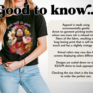 May include: Black t-shirt with the text "girls will be girls" above a floral portrait. The shirt also has the text "Good to know..." at the top. The shirt is made using environmentally-gentle direct-to-garment printing techniques.