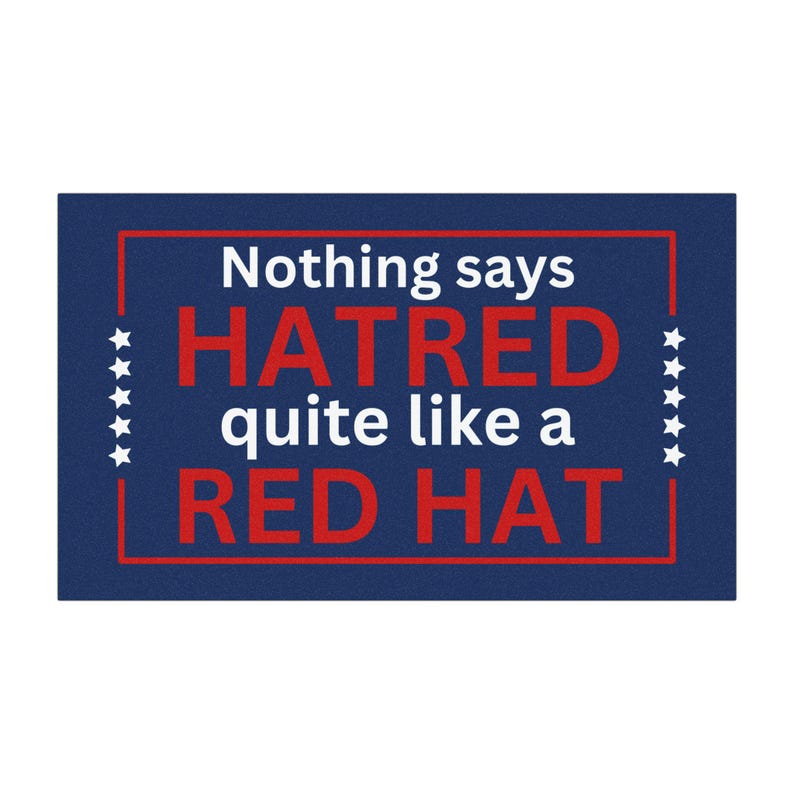 May include: A blue doormat with white stars and a red border. The text on the doormat reads "Nothing says HATRED quite like a RED HAT."