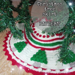 Może przedstawiać: Ręcznie robiona spódnica choinkowa z białą podstawą, ozdobiona czerwonymi, zielonymi i białymi paskami oraz elementami dekoracyjnymi. Spódnica posiada szydełkowe choinki i falisty czerwony brzeg. Tekst na zdjęciu brzmi "Christmas tree skirt PATTERN."