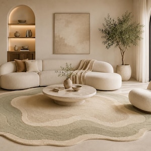 May include: A contemporary living room in neutral tones. It features a curved sofa, a circular coffee table, and a wavy rug in green and beige. An olive tree in a pot provides a natural touch to the space.