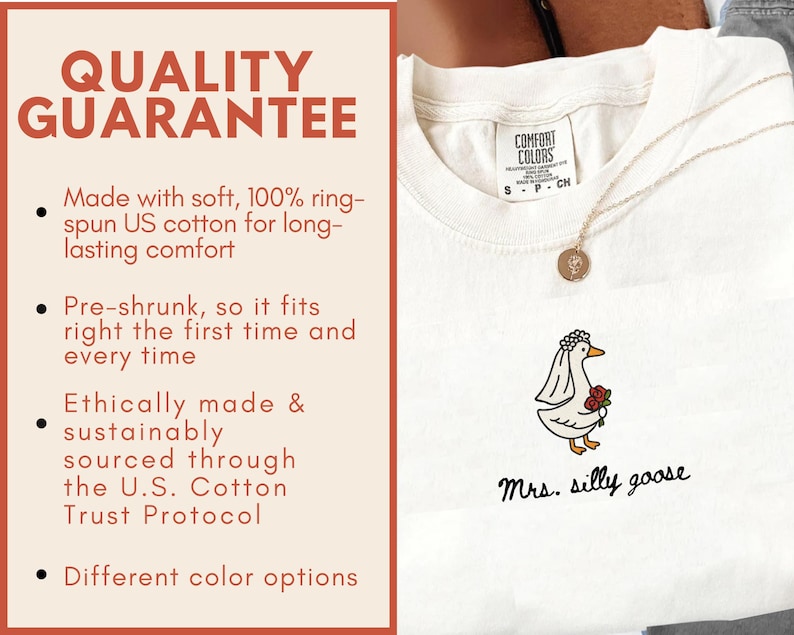 以下が含まれることがあります： 白いComfort ColorsのTシャツ。ベールとバラを持った漫画のガチョウと「Mrs. silly goose」の文字がプリントされています。Tシャツは丸首で半袖です。画像には、Tシャツの品質に関するテキストも含まれています。
