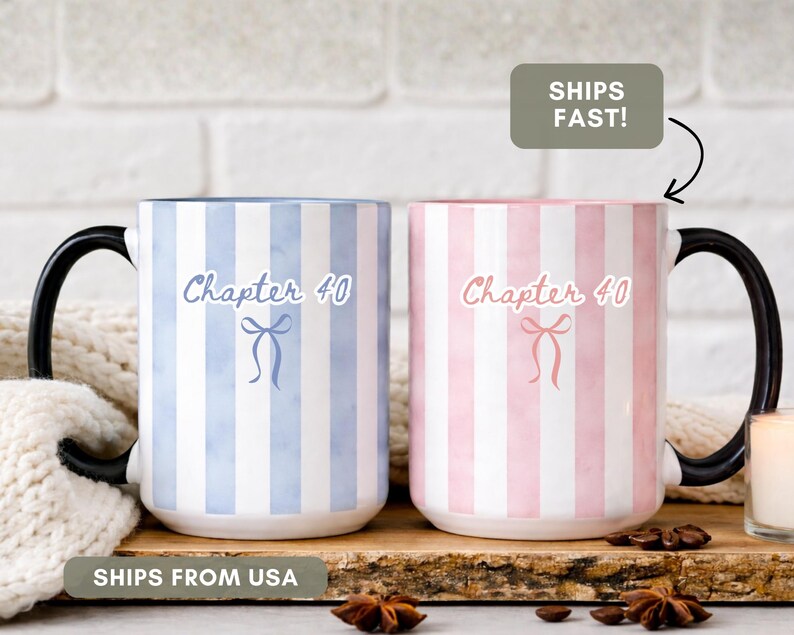 May include: Two ceramic mugs with black handles. One mug is blue and white striped, the other is pink and white striped. Both mugs have the text "Chapter 40" and a bow graphic. The mugs are on a wooden surface.