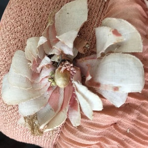 May include: A pink fabric hat with a white and pink fabric flower embellishment.