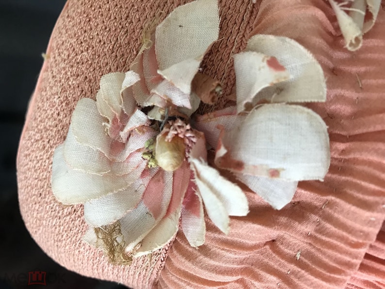 May include: A pink fabric hat with a white and pink fabric flower embellishment.