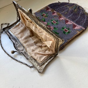 May include: A vintage beaded purse with a silver frame and a chain strap. The purse is open, revealing a pink satin lining.