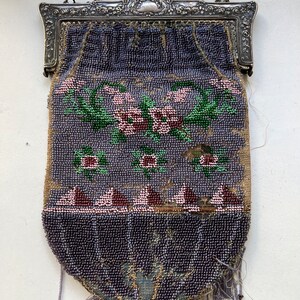 May include: A vintage beaded purse with a silver clasp and chain. The purse is decorated with a floral design in shades of pink, green, and purple.
