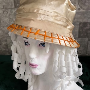 Antieke hoed uit 1920. Hoge dameshoed met kleine rand. De velden zijn geborduurd met een maaswijdte van oranje dikke draad. cilinder gemaakt van holtes