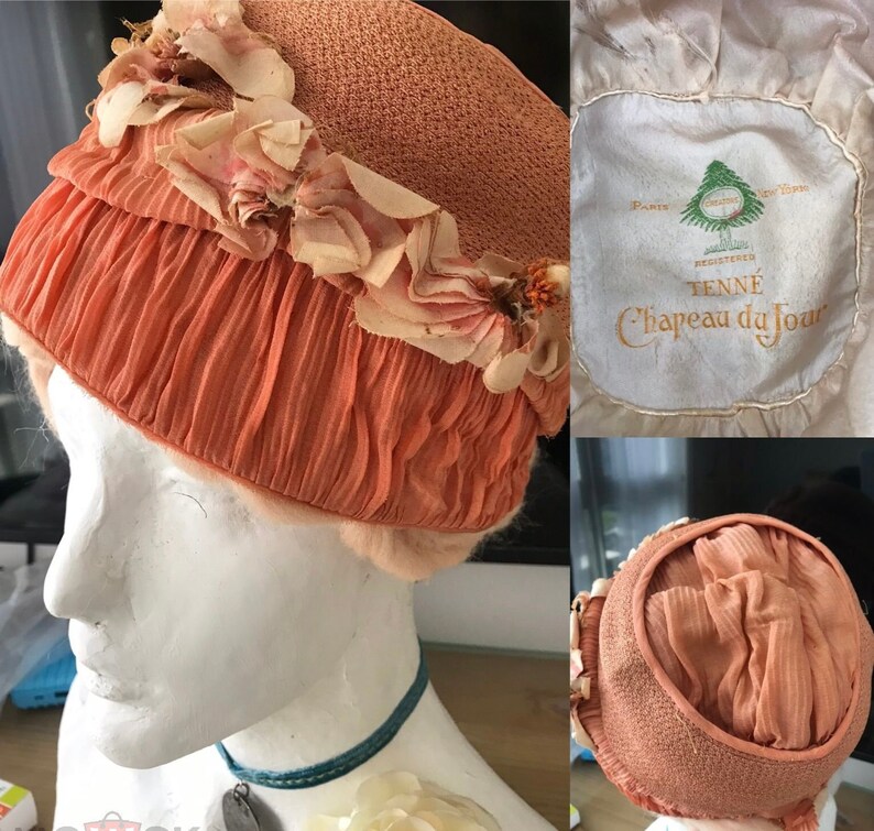May include: A peach-colored hat with a ruffled trim and floral embellishments. The hat is labeled "TENN&Eacute;  Registered  Chapeau du Jour  Paris  New York".