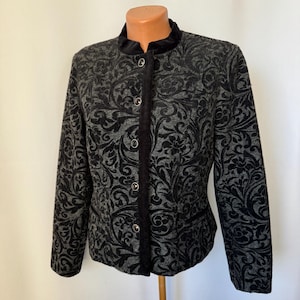 Może przedstawiać: Czarna marynarka w szary wzór z aksamitnym kołnierzem i zapięciem na guziki.