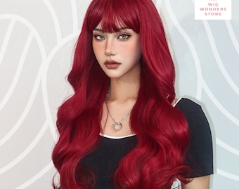 May include: A striking red wig with long, wavy hair and a fringe. The wig is styled with voluminous curls and a natural-looking hairline. The image also features a black top with the text "Ohme studio" and a silver heart pendant. The Wig Wonders Store logo is in the upper right corner.