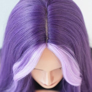 May include: A purple wig with a light purple front section. The wig is styled with long, straight hair and a natural-looking part. The wig is on a mannequin head.