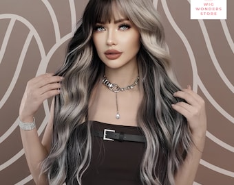 May include: A long, wavy wig with a split design, featuring black and ash blonde sections. The wig has a fringe and is styled with loose waves. The image also shows a brown top, a silver necklace, and a bracelet. The Wig Wonders Store logo is in the top right corner.