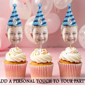 Può includere: Tre cupcake con glassa bianca, ognuno sormontato dal volto di un bambino e da un cappello da festa blu con il numero 5. I cupcake sono in pirottini rosa, con zuccherini e la scritta "ADD A PERSONAL TOUCH TO YOUR PARTY".
