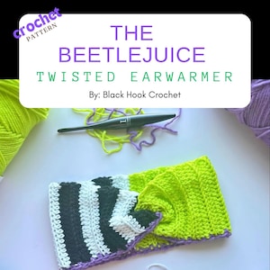 May include: A green, black, and white striped crochet ear warmer with a purple edge. The ear warmer is twisted and has a green crochet flower on one side. The text "THE BEETLEJUICE TWISTED EARWARMER By: Black Hook Crochet" is displayed above the ear warmer.