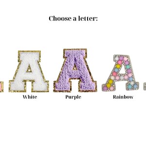 May include: Five letter A patches with the text Choose a letter above them. The options are pink, white, and purple textured patches with gold borders, a rainbow-colored beaded patch, and a white pearl-embellished patch on a silver base.
