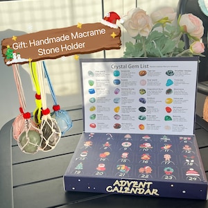 May include: A blue and black advent calendar with 24 numbered doors. Each door has a different illustration. The calendar is open to reveal a list of crystal gems with their names and descriptions. The calendar is surrounded by handmade macrame stone holders with various colored stones.