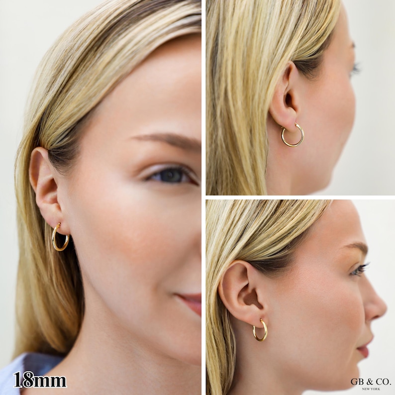 May include: A pair of gold hoop earrings with a smooth, polished finish. The earrings are circular in shape and measure 18mm in diameter. The design features a simple, continuous metal band that secures through the earlobe.