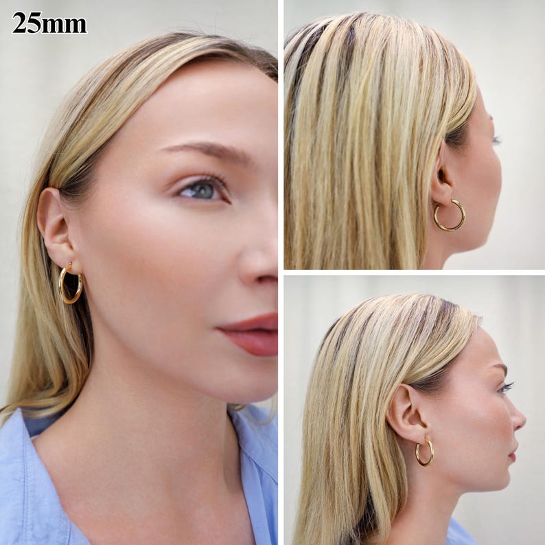 May include: A pair of gold-toned hoop earrings with a smooth, polished finish. The circular earrings have a diameter of 25mm as indicated by the text in the upper left corner. The hoops feature a simple, continuous design that secures through the earlobe.