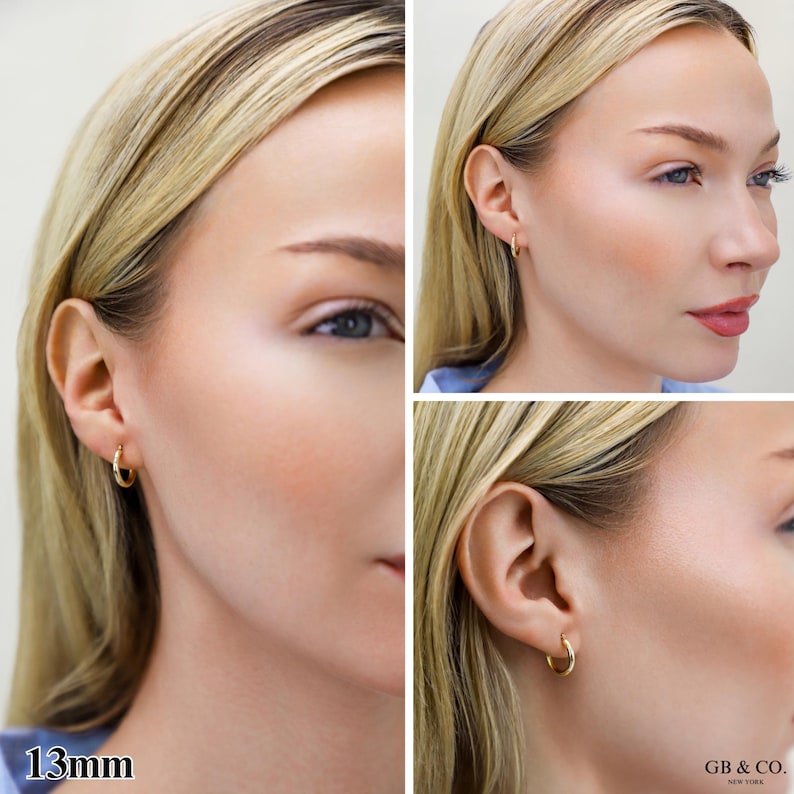 May include: A small, polished gold hoop earring with a 13mm diameter. The earring features a simple, circular design that sits securely in the earlobe. The metal has a smooth, reflective surface that catches the light, providing a clean look.