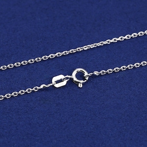 May include: A silver chain necklace with a lobster clasp closure. The chain is made of small, linked circles.