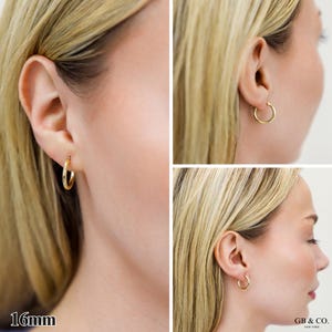 May include: A pair of gold hoop earrings with a smooth, polished finish. The earrings are circular in shape and feature a 16mm diameter as indicated by the text. The design is simple and classic, consisting of a thin, continuous metal band.