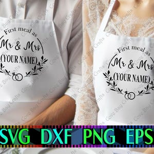 May include: White aprons with black text that reads "First meal as Mr & Mrs (YOUR NAME)". The design includes a circular wreath and two rings. The bottom of the image shows the words "SVG DXF PNG EPS".
