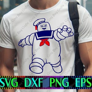 Puede incluir: Camiseta blanca con una ilustración de dibujos animados de Stay Puft Marshmallow Man en azul marino, rojo y blanco. El sombrero tiene el texto "STAY PUFT". La parte inferior de la imagen tiene el texto "SVG DXF PNG EPS".