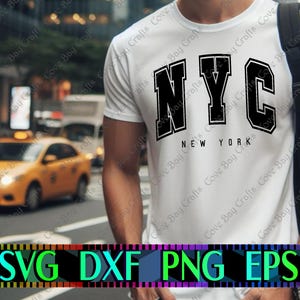 May include: A white short-sleeved t-shirt featuring the bold black text NYC in a collegiate font, with the words NEW YORK printed in smaller black letters underneath. The shirt is worn with a black backpack strap visible over the shoulder.