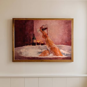 Puede incluir: Una pintura enmarcada representa a una persona en una bañera vertiendo vino tinto. La obra de arte presenta una paleta de colores cálidos con tonos de rojo, naranja y blanco. La pintura se exhibe en una pared color crema en un baño.