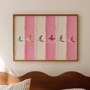 May include: A framed artwork featuring six surfers on colorful surfboards. The background has alternating vertical stripes of white and pink. The artwork is displayed above a wooden bed frame with striped bedding.
