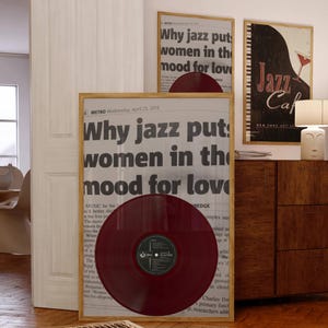 May include: A framed newspaper article with the headline "Why jazz puts women in the mood for love" and a red vinyl record in front of it. The article is from the Metro newspaper, dated April 23, 2014.